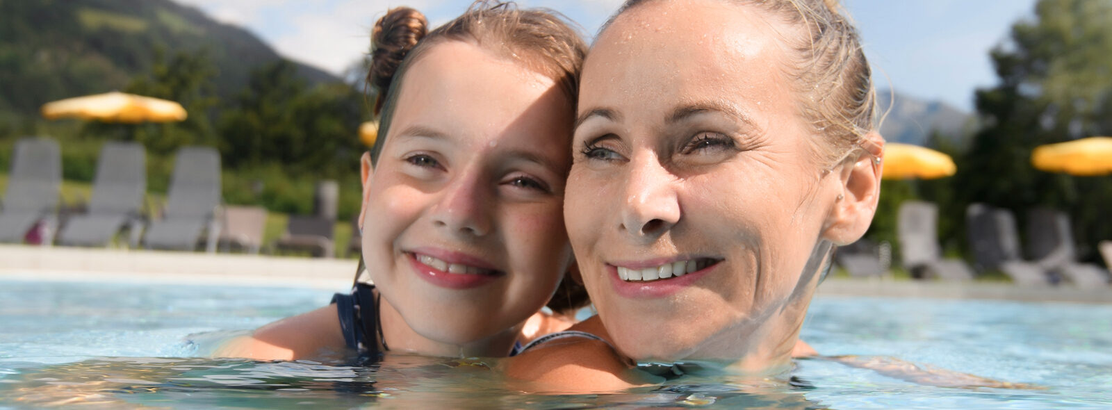 Alpenthermegastein Familyworld Aussenbecken Mutter mit Tochter im Wasser